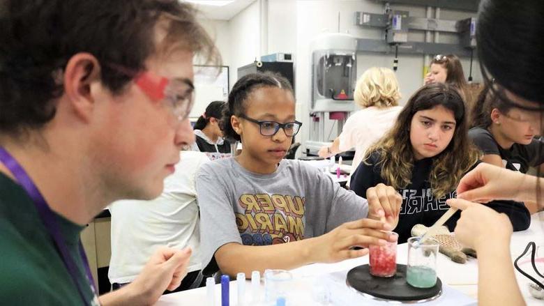 几个年轻人在十大网投平台信誉排行榜贝伦德分校的实验室里研究有色液体